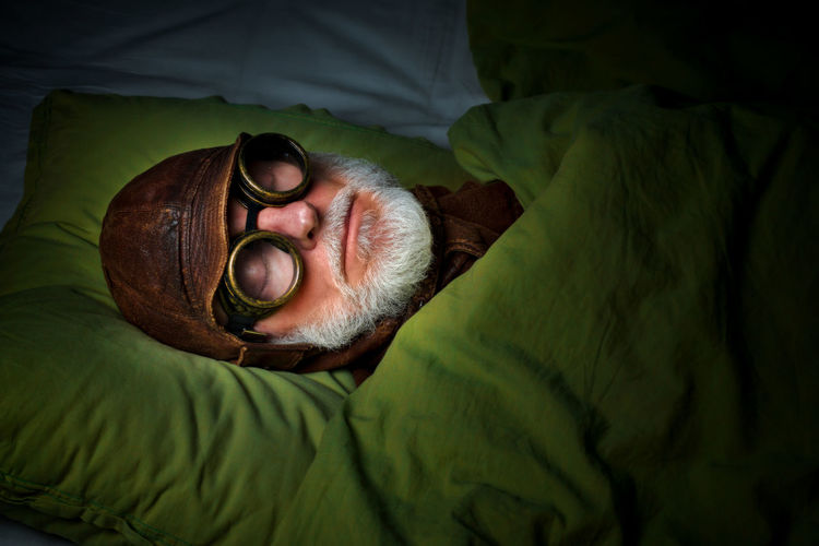 High angle view of senior man sleeping on bed at home