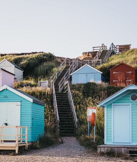 Stairs to the beach between colourful beach huts in milford on sea, uk.