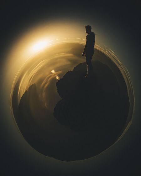 Little planet effect of silhouette man standing on mountain during sunset
