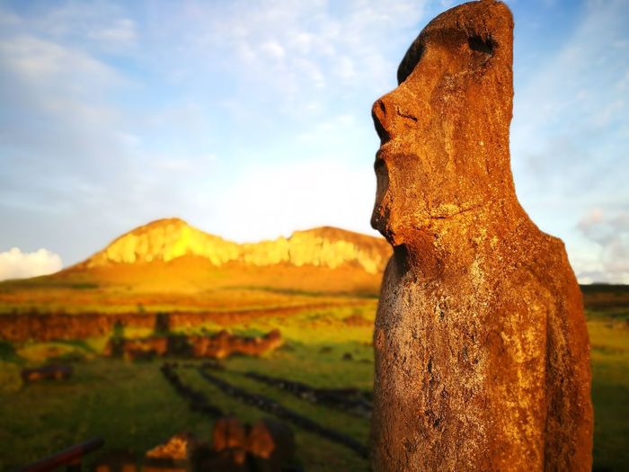 Moai statue at easter island against mountain during sunrise