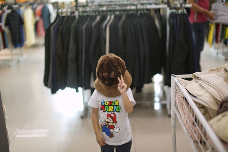 Kid with big hat in bundle shop