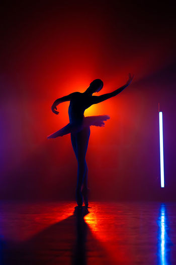 Full length of silhouette man standing on illuminated stage