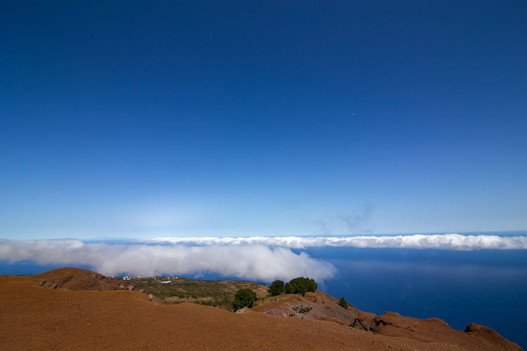 Panoramic view of land against blue sky
