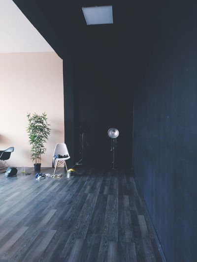 Empty chairs and table against wall in building