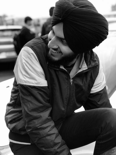 Young man in turban sitting outdoors