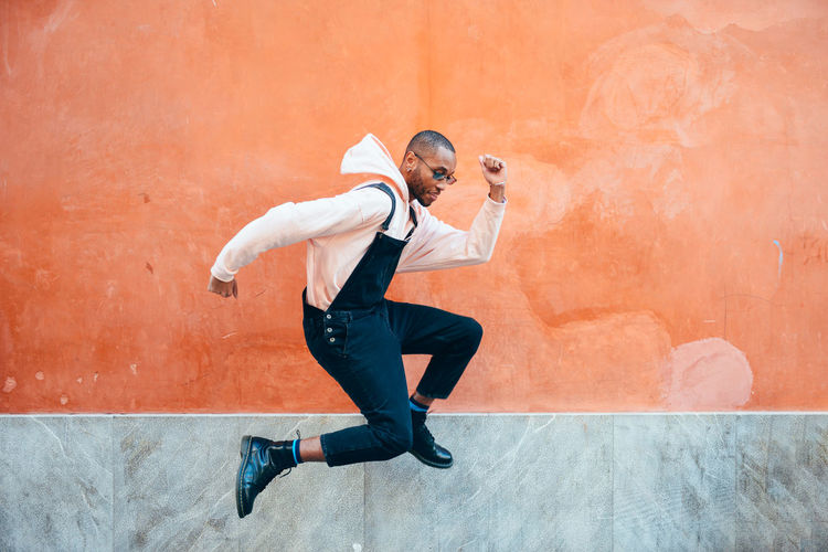YOUNG MAN JUMPING AGAINST WALL