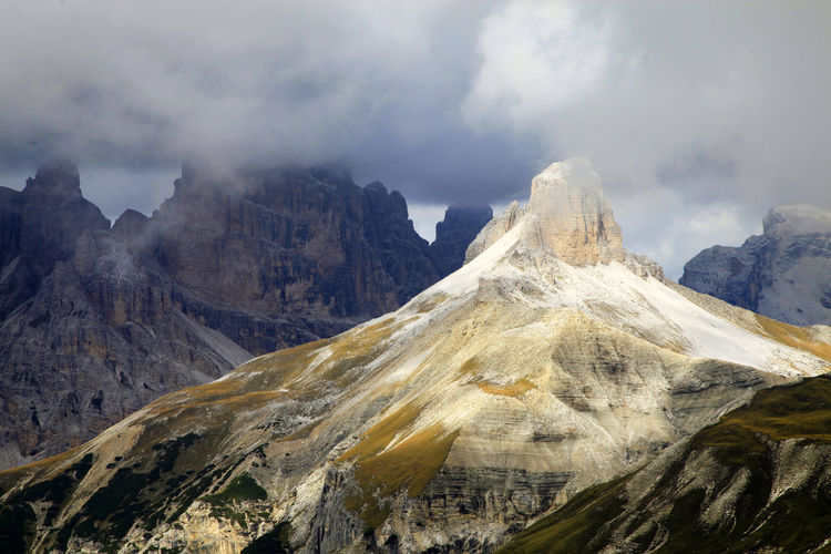 Idyllic view of dolomites against cloudy sky