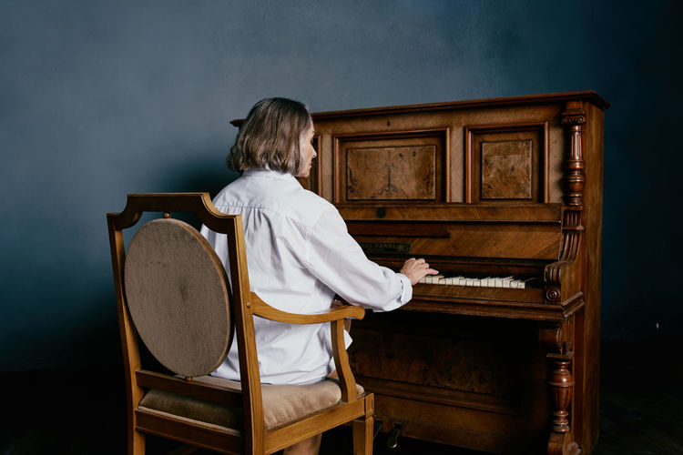 Rear view of man playing piano