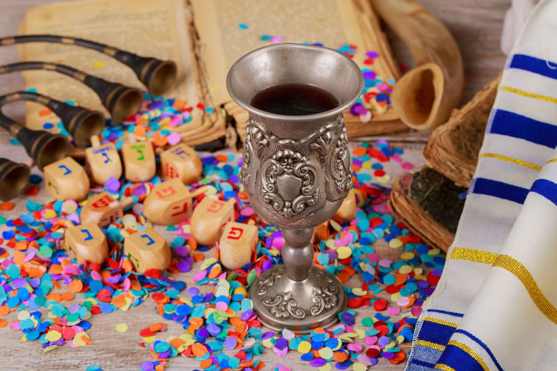 High angle close-up of toy blocks with colorful confetti and drink on wooden table