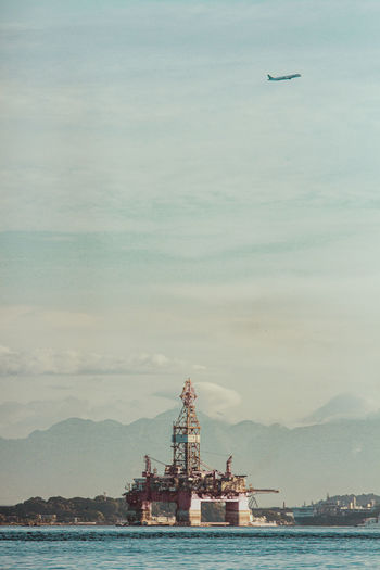 Ship in sea against cloudy sky