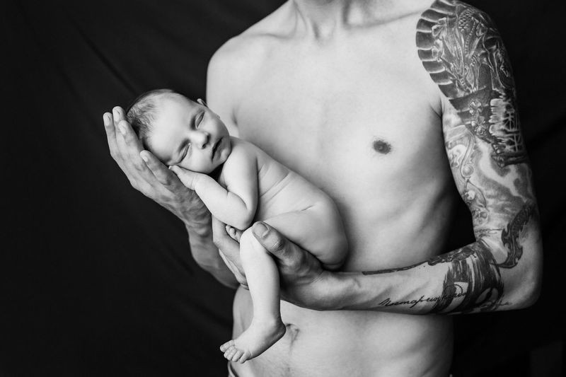 Midsection of shirtless man against black background