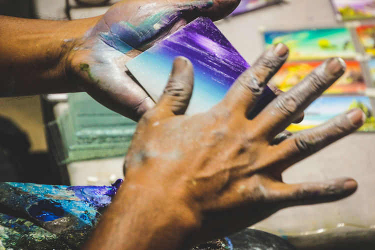 Cropped hands of male artist making artwork in workshop