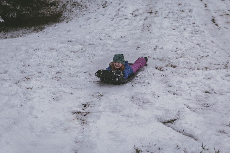 High angle view of girl on snow covered field