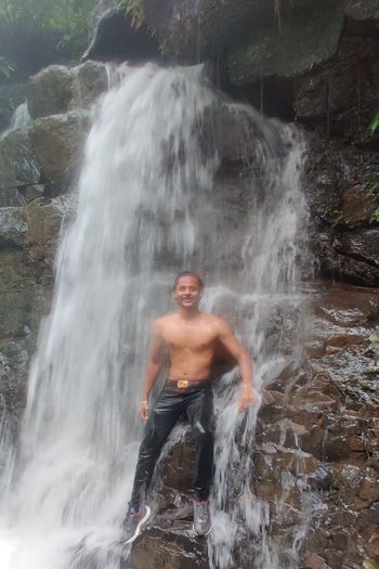Young man looking at waterfall