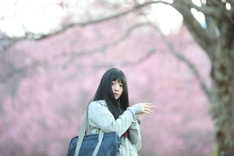 Woman standing by cherry tree