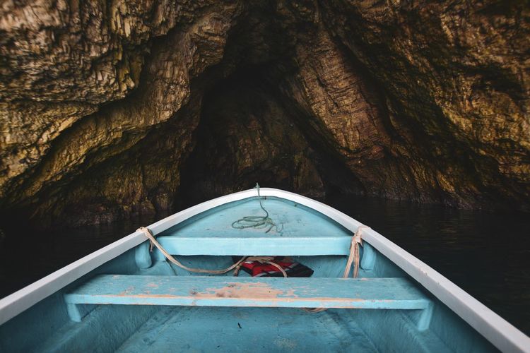 Small boat in sea inside a cave