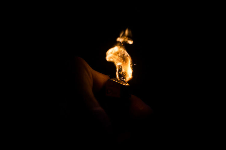 Illuminated cigarette lighter against black background