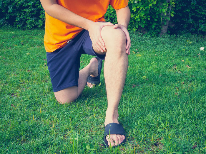 Low section of man sitting on field