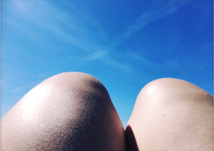 Cropped image of person against blue sky