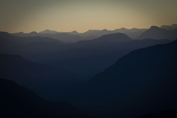 Scenic view of silhouette mountains against sky during sunrise 
