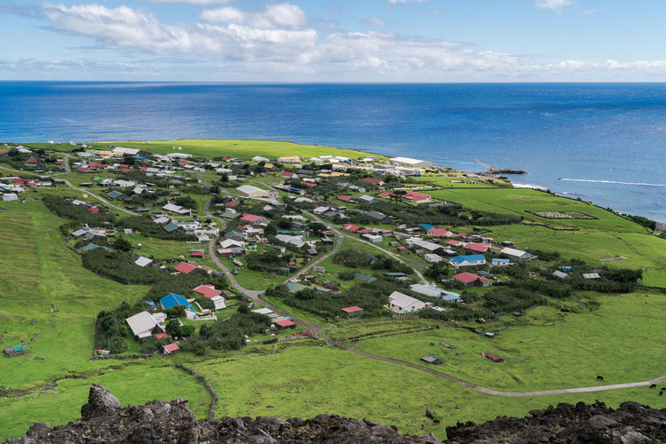 High angle view of village and sea against sky