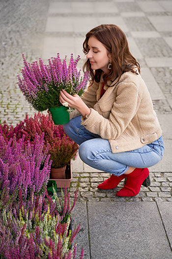 Woman with pink flowers against wall