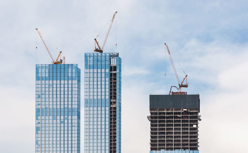 Construction site of skyscraper buildings and cranes against sky