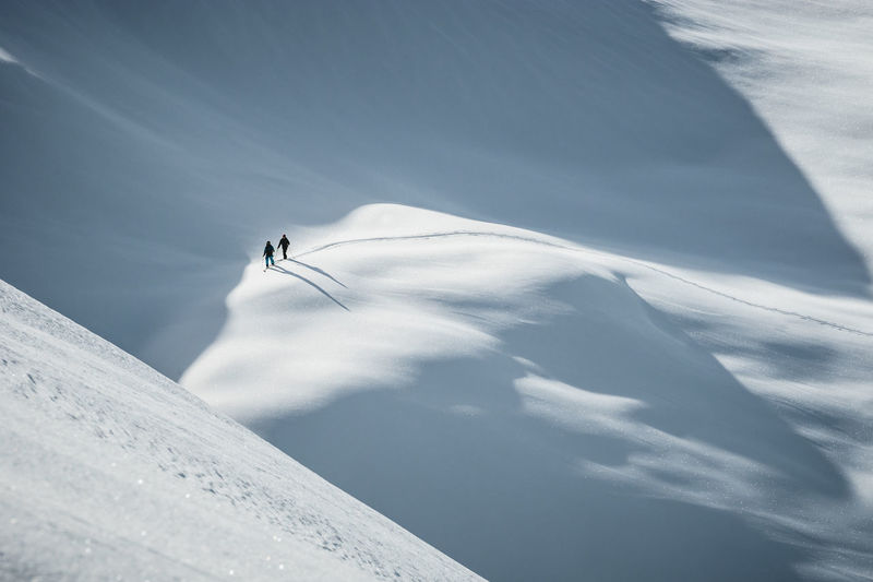 Silhouette of two skiers ski touring in the backcountry of the alps in lienz, austria.