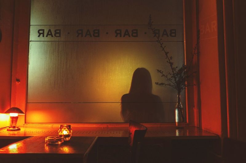 Shadow of woman on glass in bar