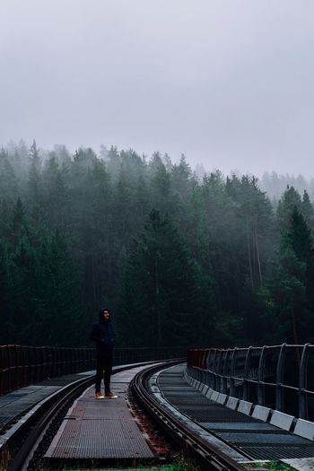 Rear view of man walking on footbridge