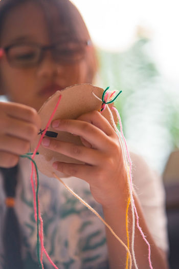 Close-up of girl making multi colored decoration