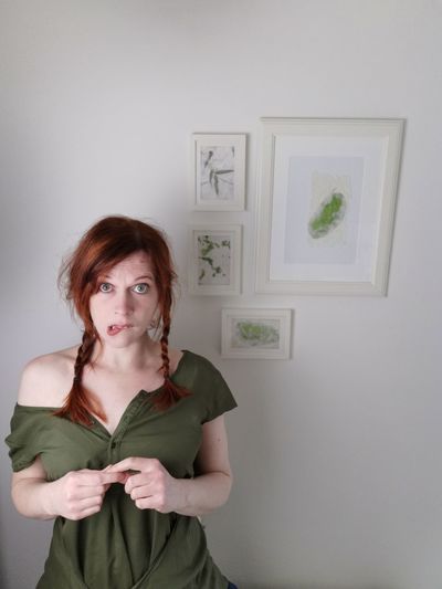 Portrait of woman standing against wall