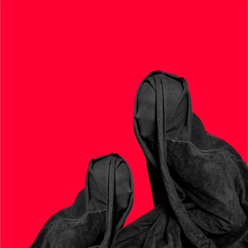 Midsection of person covering face against red background