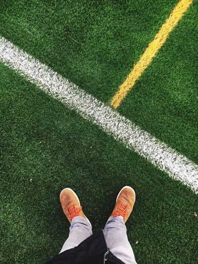 Low section of man standing by markings on playing field