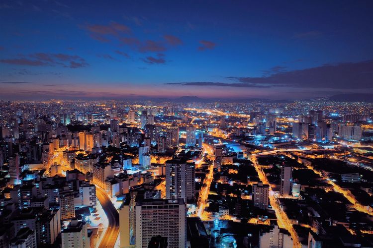 High angle view of illuminated city against sky at night