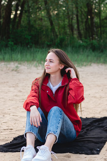 Beautiful young woman sitting on beach