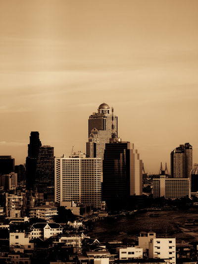 Bangkok city tall buildings by the chao phraya riverside in brown monochrome