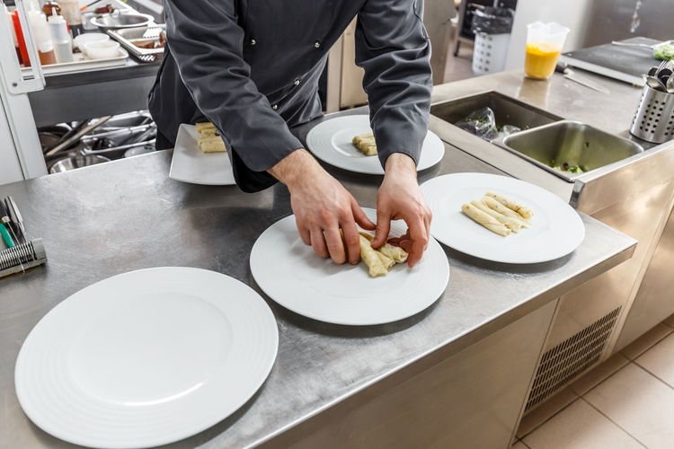 Midsection of chef preparing food in kitchen