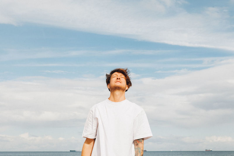 Man standing by sea against sky