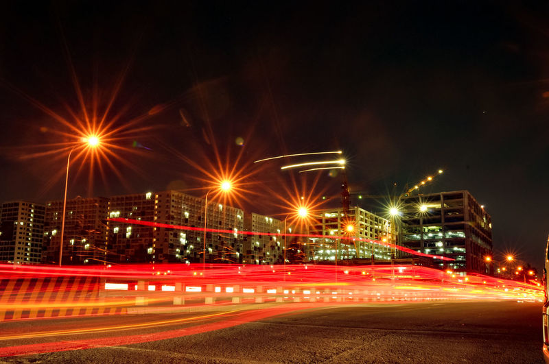 Light trails on road against sky at night