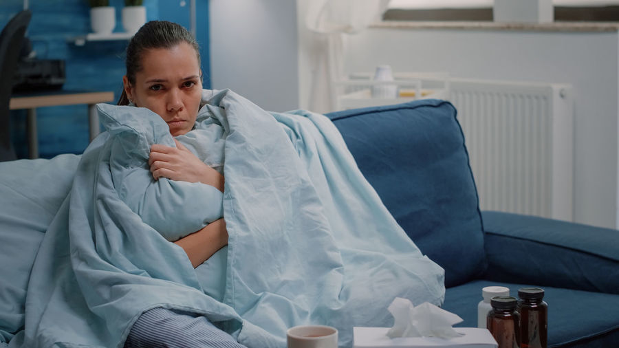 Sick woman resting on sofa at home