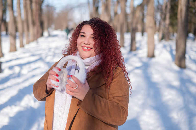 Portrait of smiling young woman holding snow