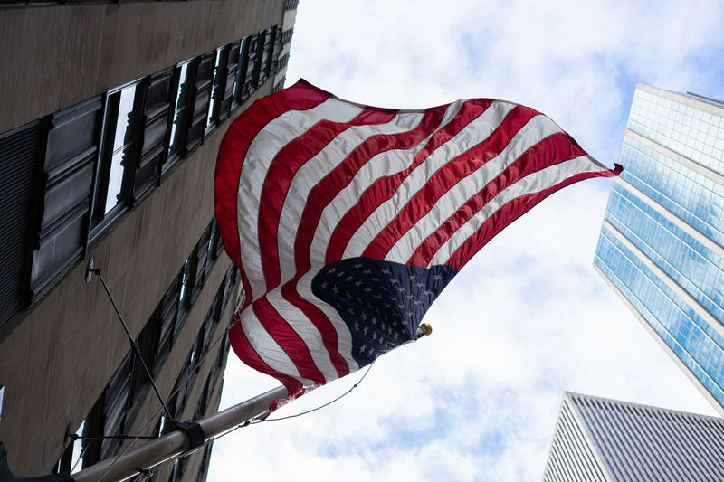 Low angle view of flag against buildings against sky