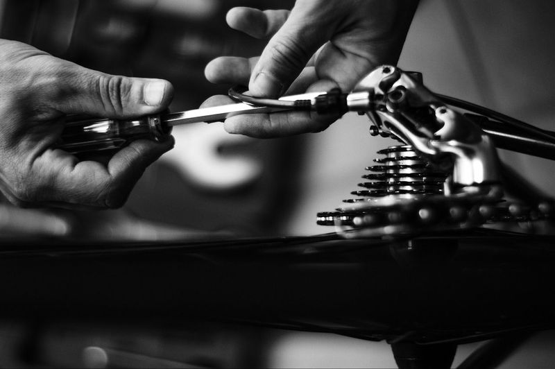 Cropped image of man repairing gear of bicycle