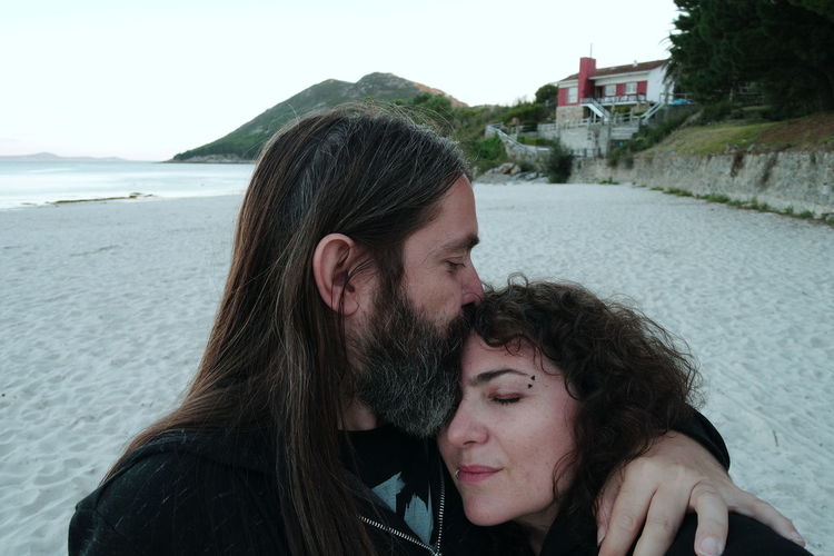 Portrait of couple kissing against sea