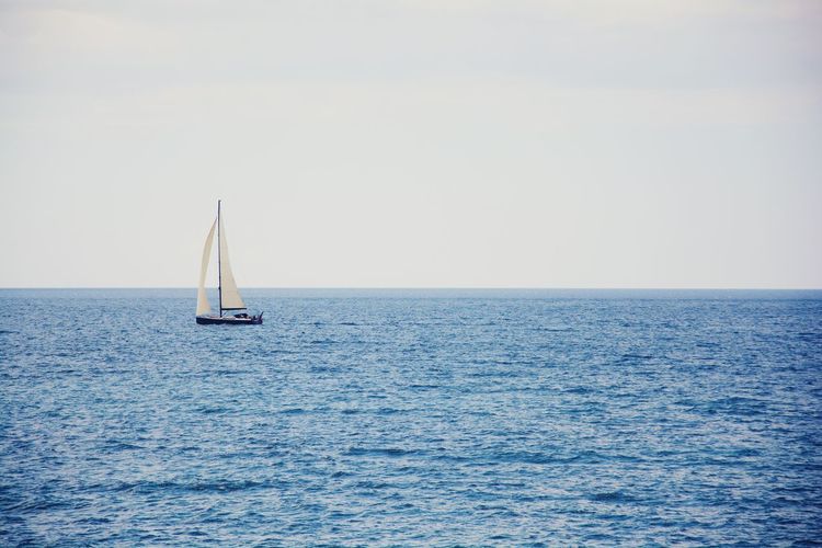 Boat sailing on sea against sky