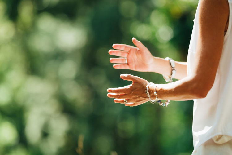 Woman practicing tai chi chuan outdoors. close up on hand position