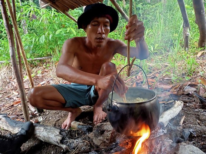 Cropped image of man preparing food on fire