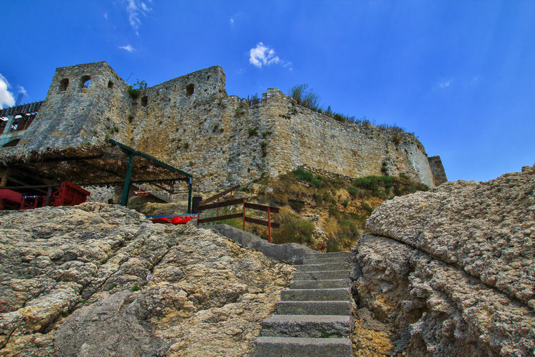 Low angle view of castle wall and stairs against sky