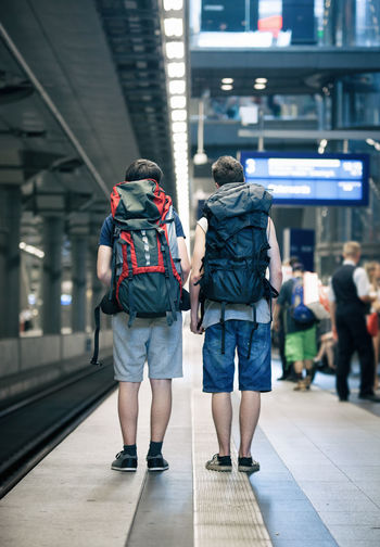 Rear view of people walking in railroad plaform